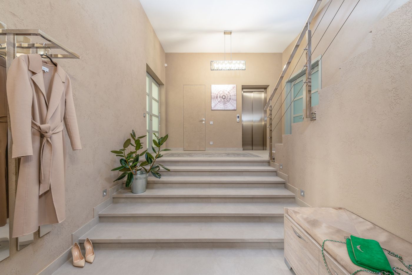 Ascenseur privatif aux portes en inox dans l'entrée d'une maison contemporaine, près de l'escalier